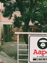 Road sign by trees in city