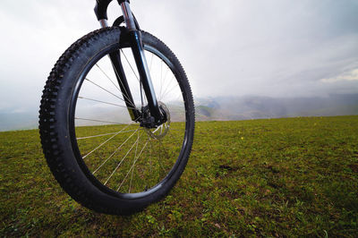 Mountain biker standing on a hill or field, close-up of a wheel. active and sports recreation