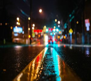 Illuminated city street during rainy season at night