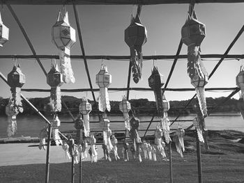 Low angle view of chain hanging by railing against sky