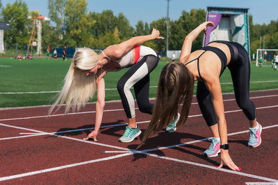 Side view of woman exercising on field