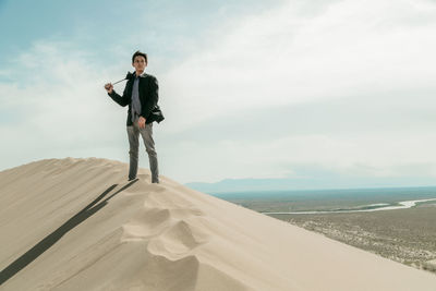 Portrait of a young man standing against sky