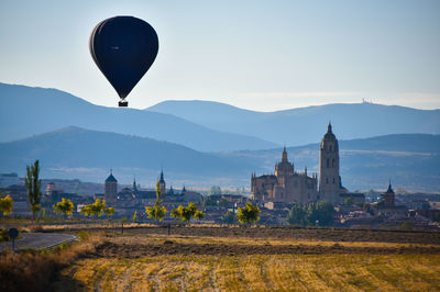 Silhouette of hot air balloon with landscape and mountain against sky