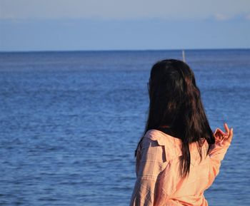 Rear view of woman against sea