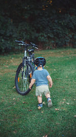 Boy with bicycle on field