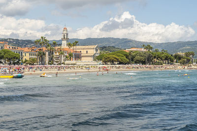 View of building by sea against cloudy sky