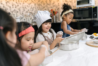 Girls preparing food on table at home