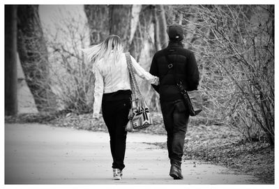 Rear view of couple walking on road