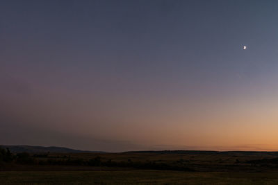 Scenic view of field against clear sky at sunset