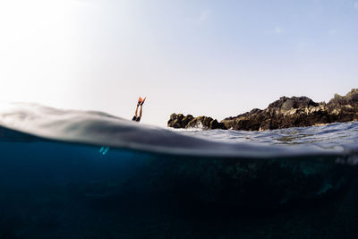 Young adult jumping into sea water in summer