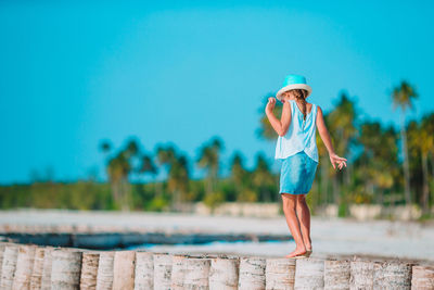 Woman wearing hat standing against blue sky