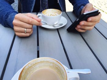 Woman holding coffee cup on table