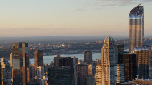 Skyscrapers in city against sky during sunset