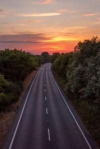 Empty road against sky during sunset