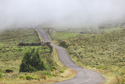 Road amidst land against sky