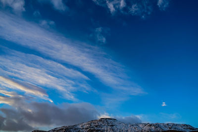 Low angle view of mountain against blue sky