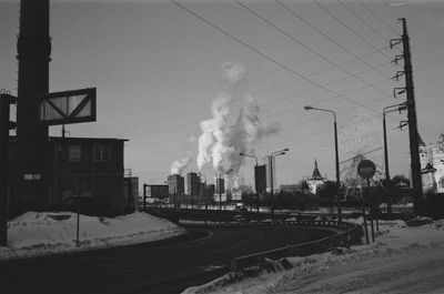 Smoke emitting from factory against sky