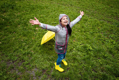 Baby boomers and mental health. happy senior woman in yellow rain coat with yellow umbrella jumping