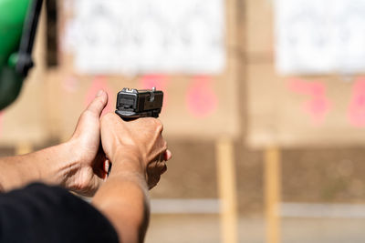 Cropped hand of person pointing gun