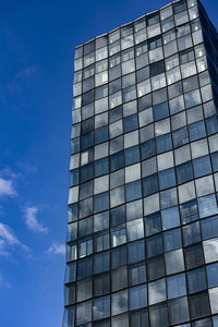 Low angle view of modern building against blue sky