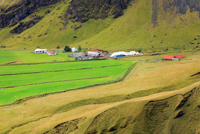 Scenic view of agricultural field by houses and mountain