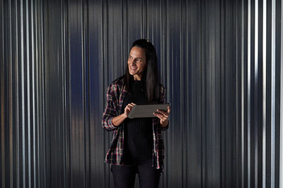 Portrait of a smiling young woman using phone