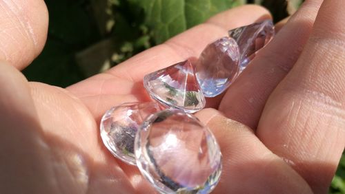 Cropped hand holding diamonds outdoors