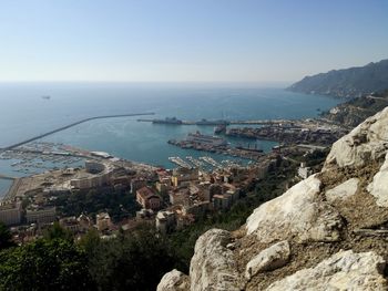 High angle view of sea and city against clear sky