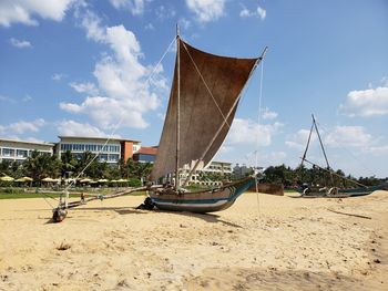 Ship moored on beach against sky