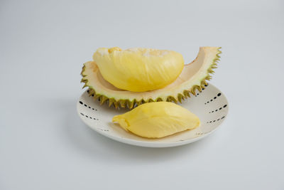 Close-up of fruit in plate against white background