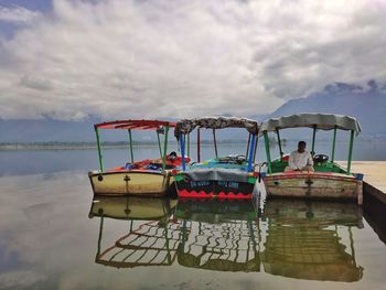 Men sitting on boat in sea against sky