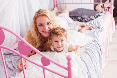 Portrait of happy girl lying on bed