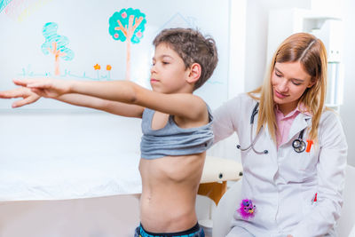 Female doctor examining boy at clinic