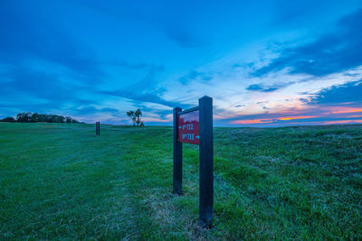 Wooden posts on field against sky