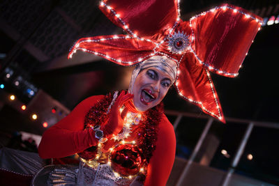 Portrait of young woman holding red light painting