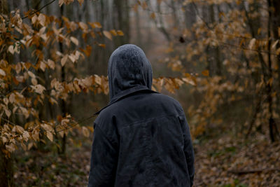 Rear view of man wearing autumn leaves