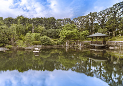 Hexagonal gazebo ukimido in the central pond of mejiro garden where ducks are resting.