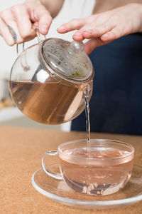 Close-up of woman pouring drink in jar