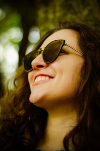 Close-up of smiling teenage girl wearing sunglasses at park