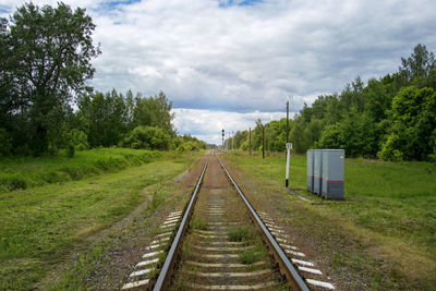 Railroad track amidst trees against sky