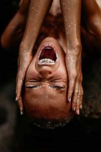 Close-up of portrait woman and human hand in water