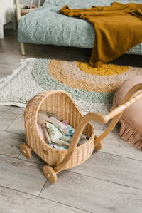 A toy wicker stroller with soft toys in it in the children's room