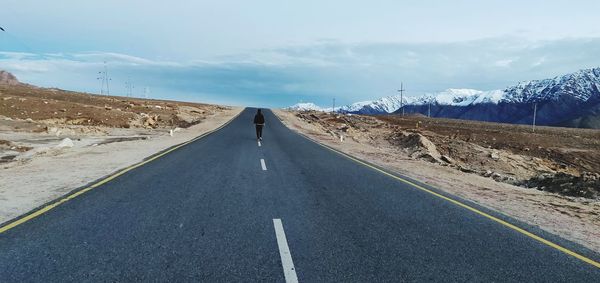 Rear view of man on road against sky