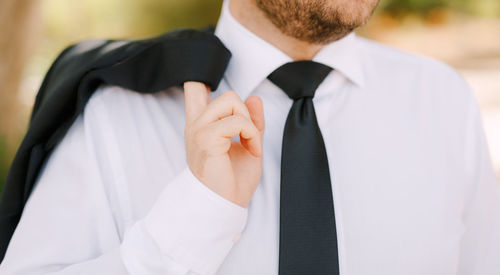 Midsection of man holding coat