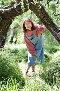 Portrait of young woman standing on field