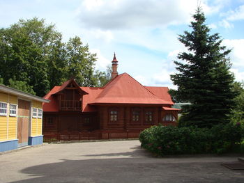 Houses by trees and buildings against sky