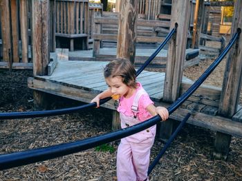 Girl carrying food in mouth while playing at playground