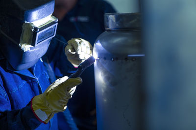 Welder in industrial plant welding tanks