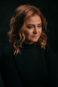 Portrait of a beautiful young woman over black background