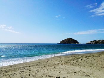 Scenic view of beach against blue sky